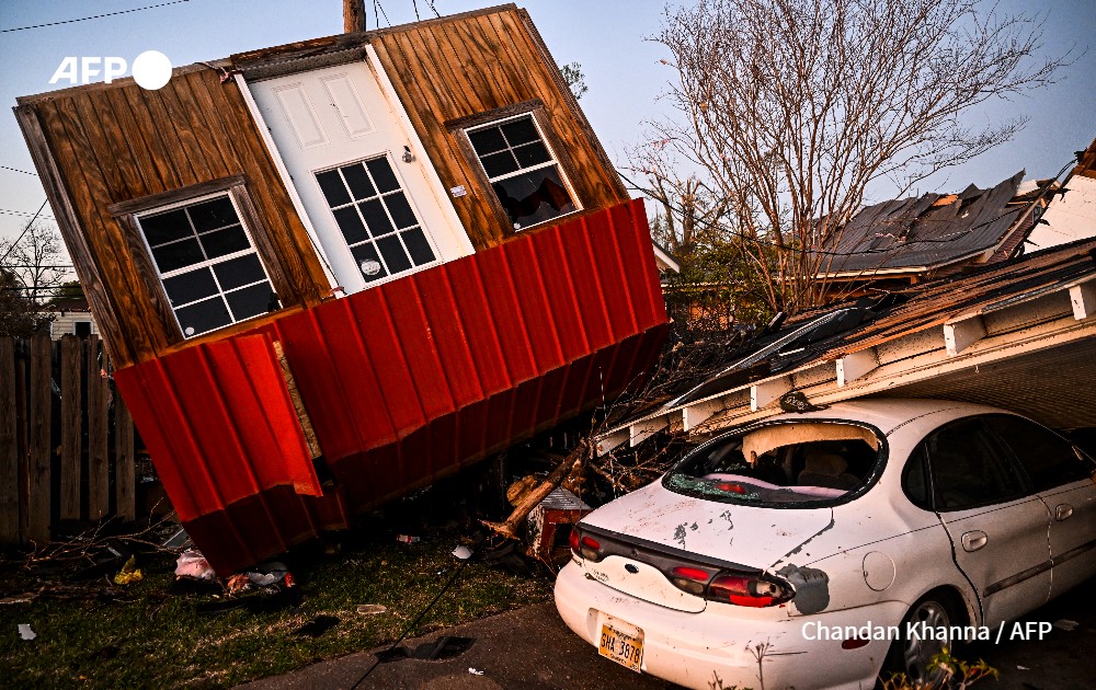 Remains of crushed house and cars after a tornado in Mississippi